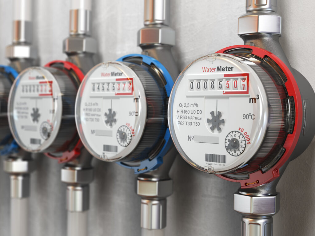 Row of water meters used for automated meter readings of cold and hot water on the wall background. 3d illustration