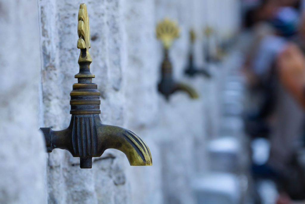 Water taps on a wall outside in a row