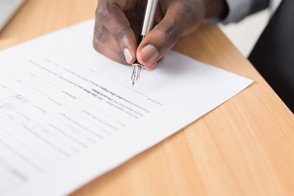 A hand with a pen signing an energy contract