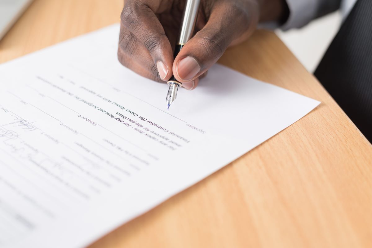A hand signing an energy contract