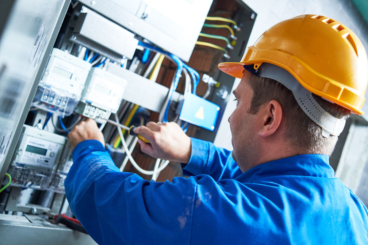 An engineer in a hardhat upgrading a business energy meter