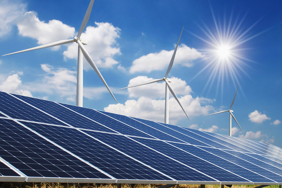 Solar panels in front of wind turbines