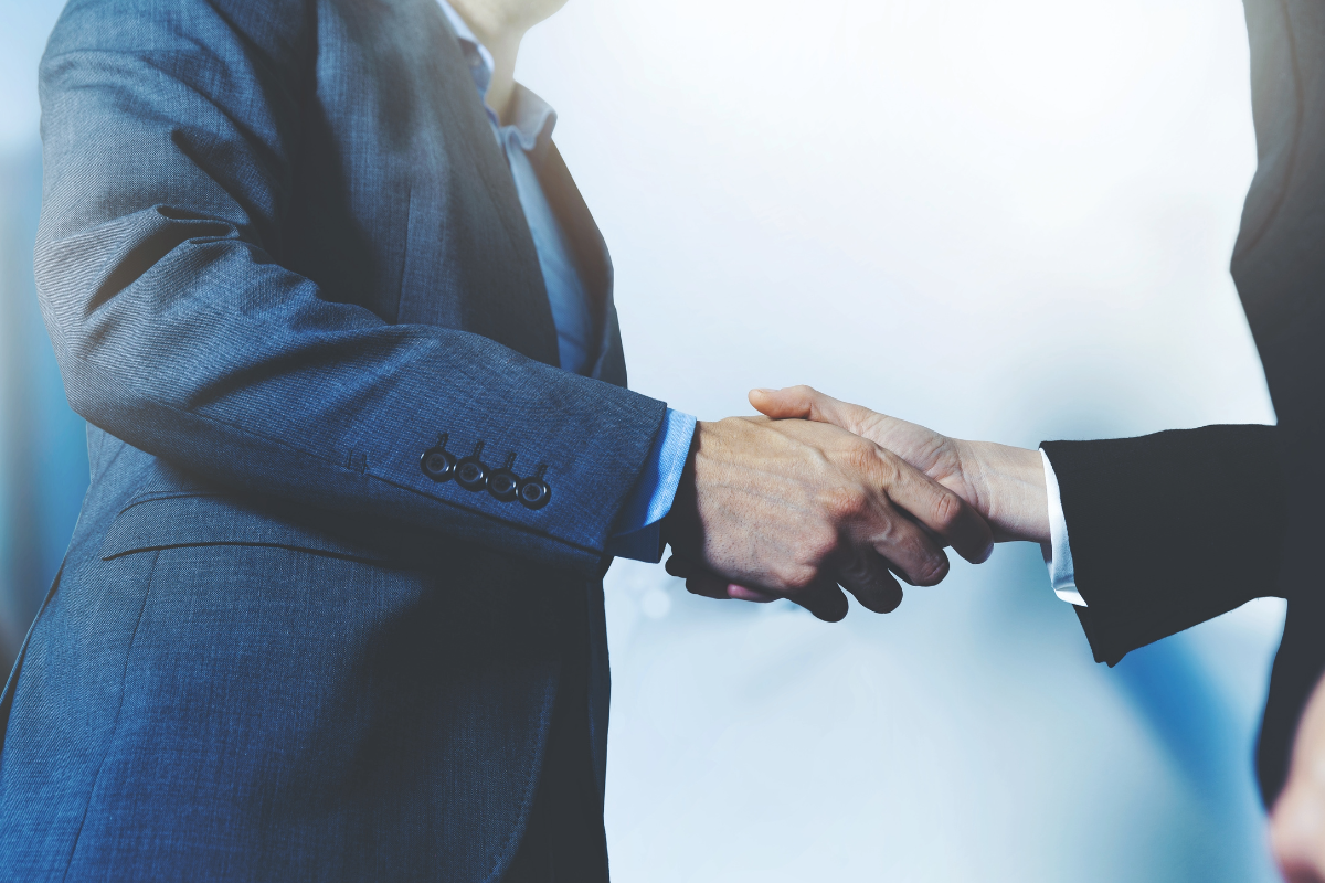 Two people in suits shaking hands