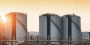Large industrial gas storage tanks at sunset, highlighting European gas storage levels and potential wholesale gas price volatility ahead of winter 2026/27.
